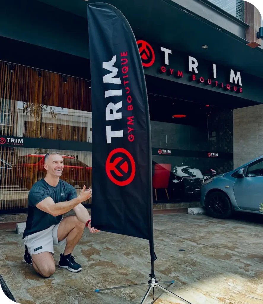 Mirko Micunovic entrenador personal en Lima arrodillado frente a bandera de su gimnasio Boutique