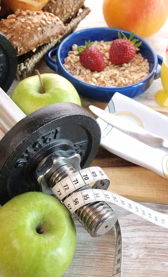 Imagen de pesas con manzanas y ensaladas