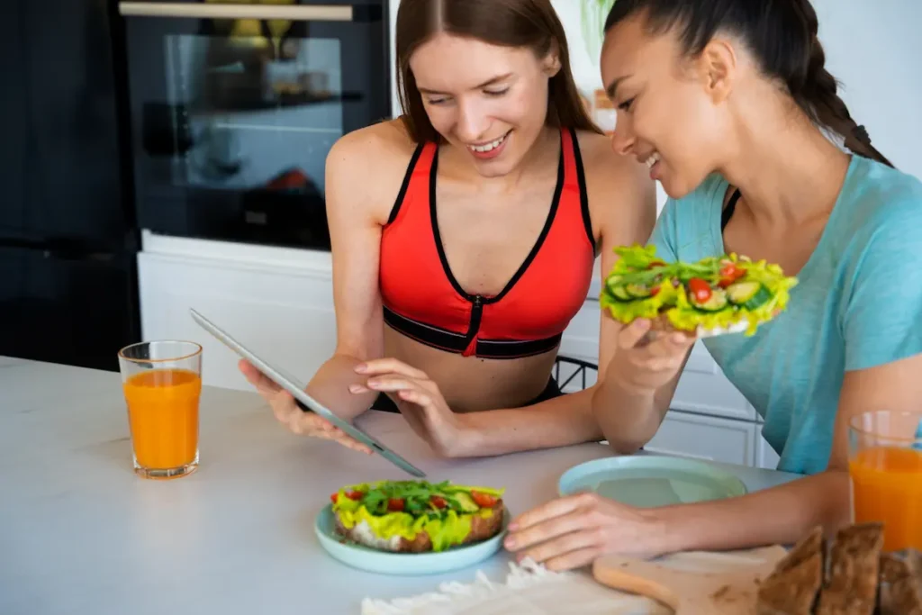 Chicas comiendo ensalada para mantener hábitos saludables